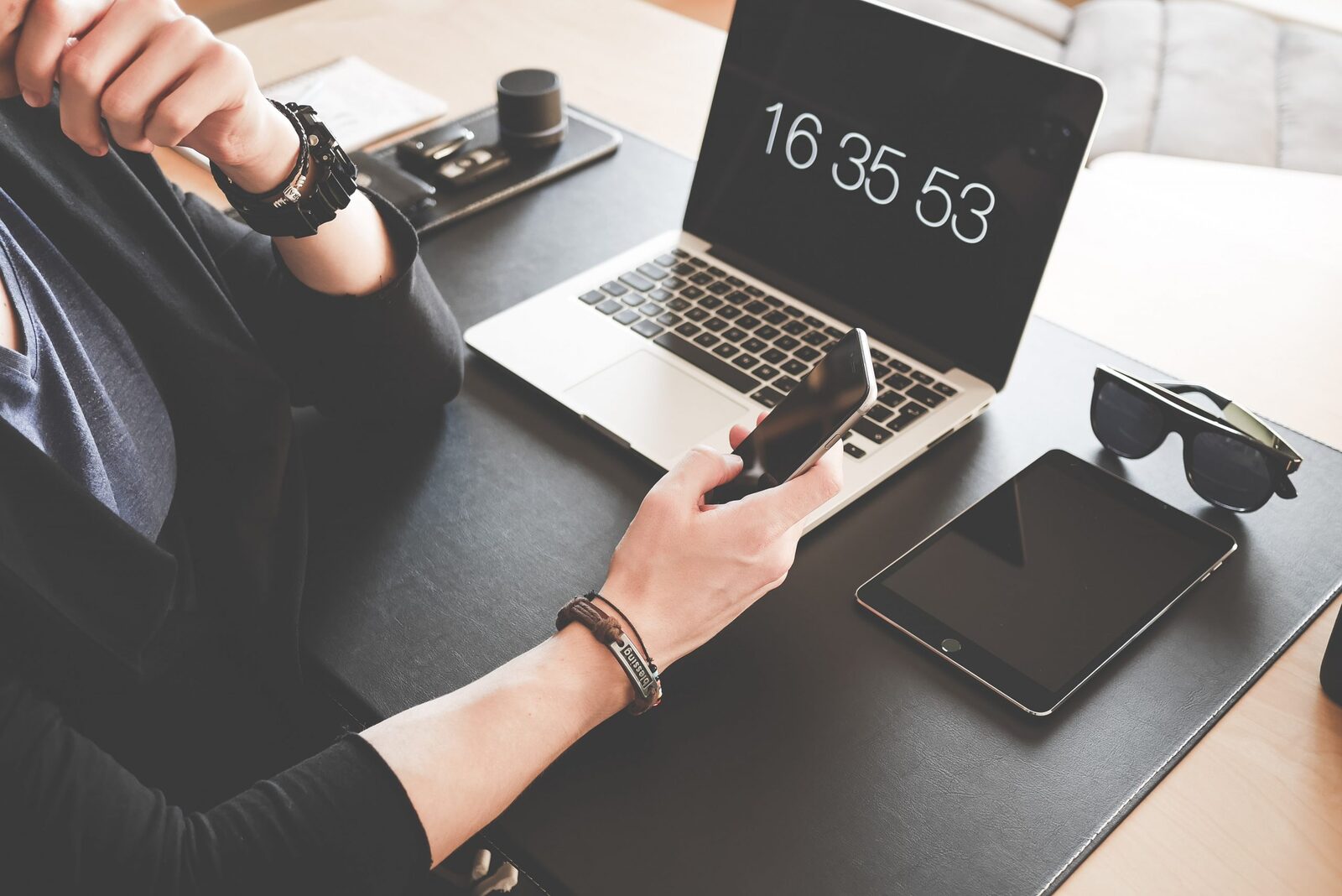 Een rustige, opgeruimde digitale werkplek met laptop, telefoon en tablet